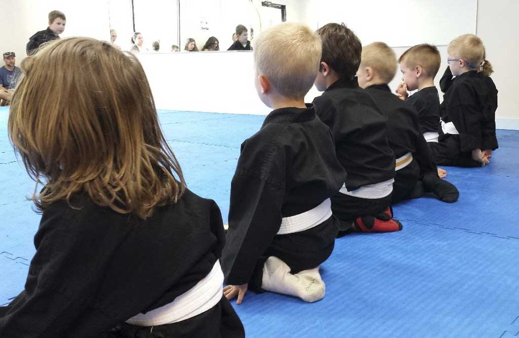 Martial Way News - August 2026 1 Children in black martial arts uniforms sit in a line on the training mat during a youth class at Martial Way.